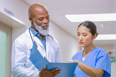 Male doctor speaking with female nurse