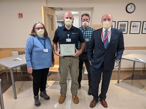 Andy Donato with certificate naming him Employee of the Year, with colleagues